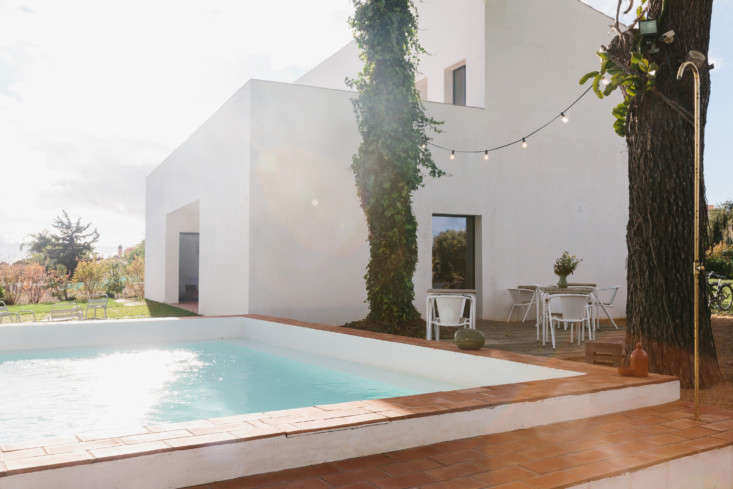 A small outdoor pool surrounded by warm-toned terracotta tiling.