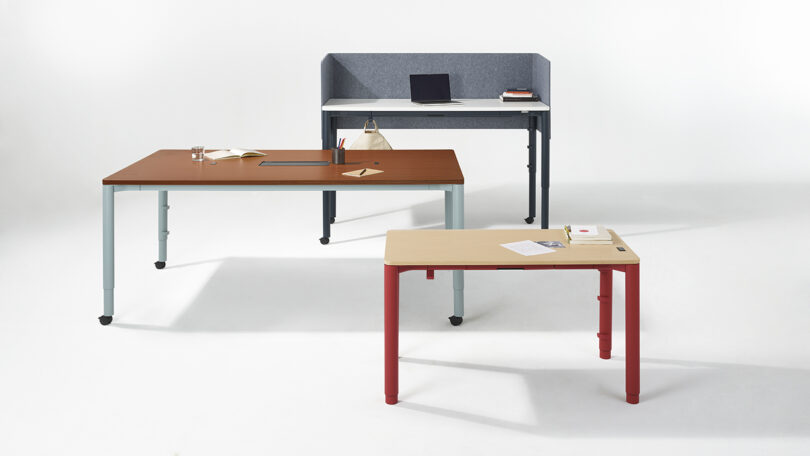 Three Spout desks set at different heights to show the motorized adjustment range.