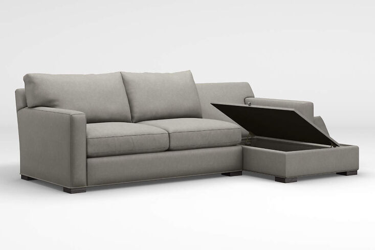 A close-up of the Crate & Barrel Axis sectional showing the side-opening top of the storage compartment.
