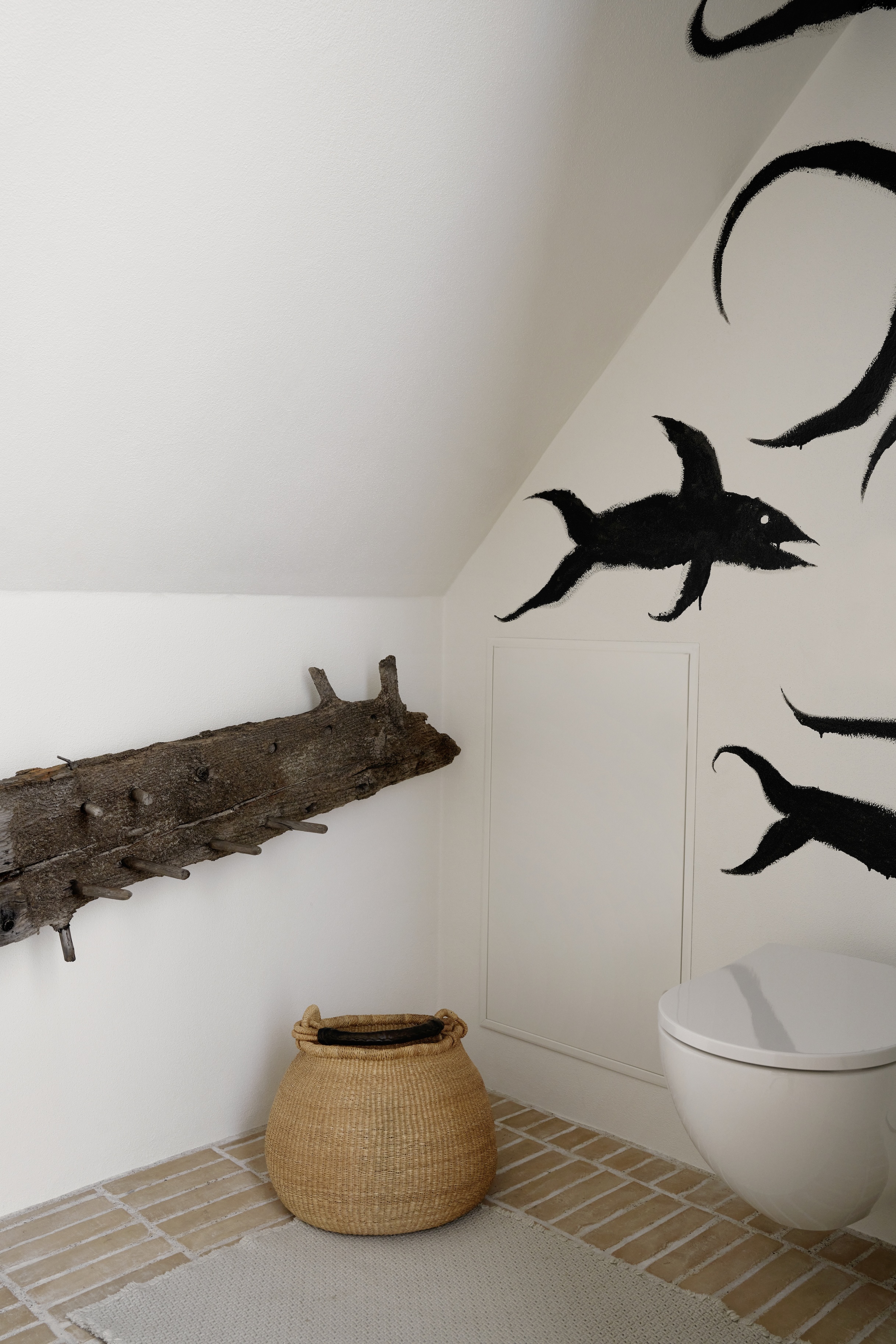 A detailed shot of a fish mural painted on a white wall next to a rustic wooden beam.