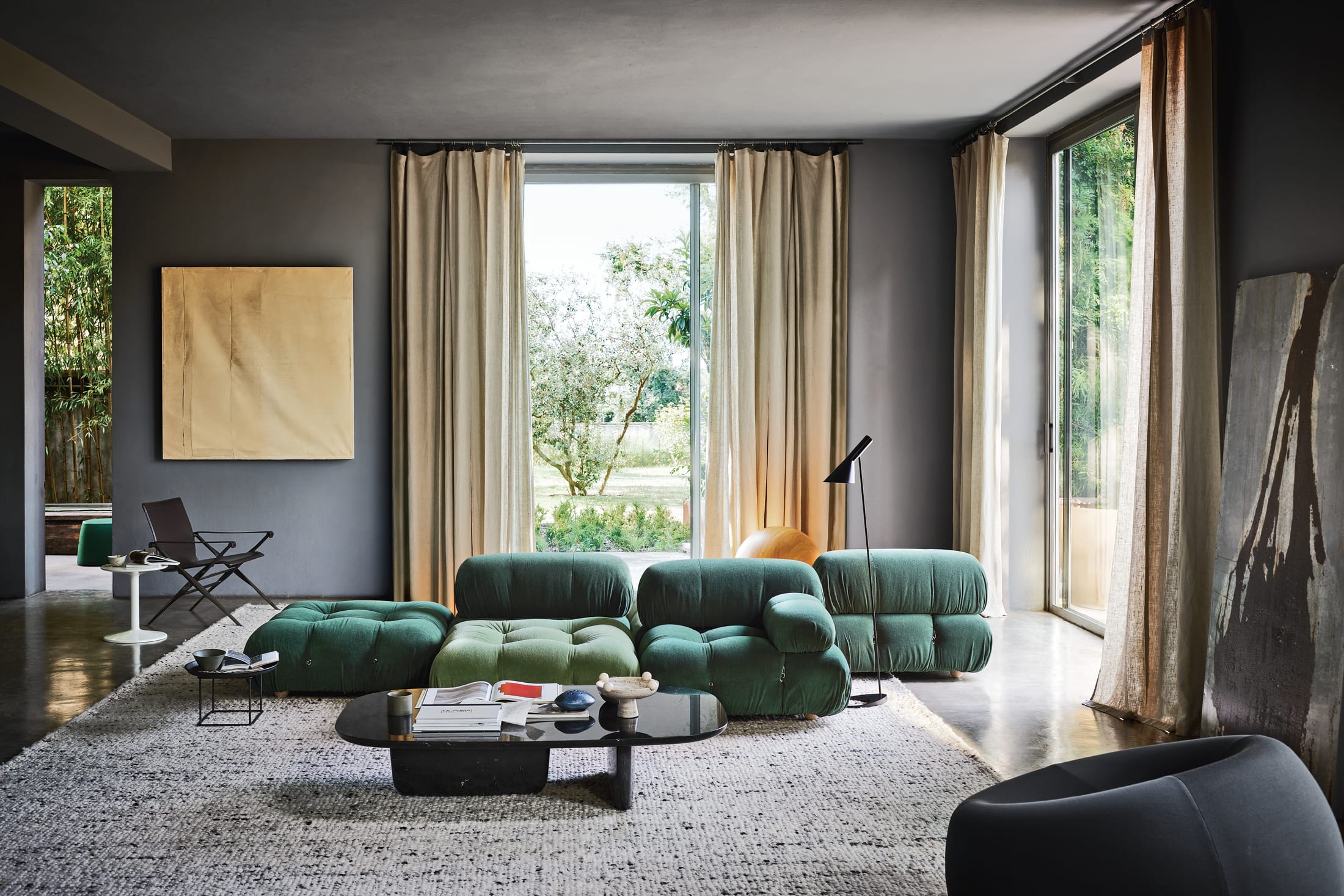A wide shot of a modern living room featuring a Camaleonda sofa in a warm, neutral interior.