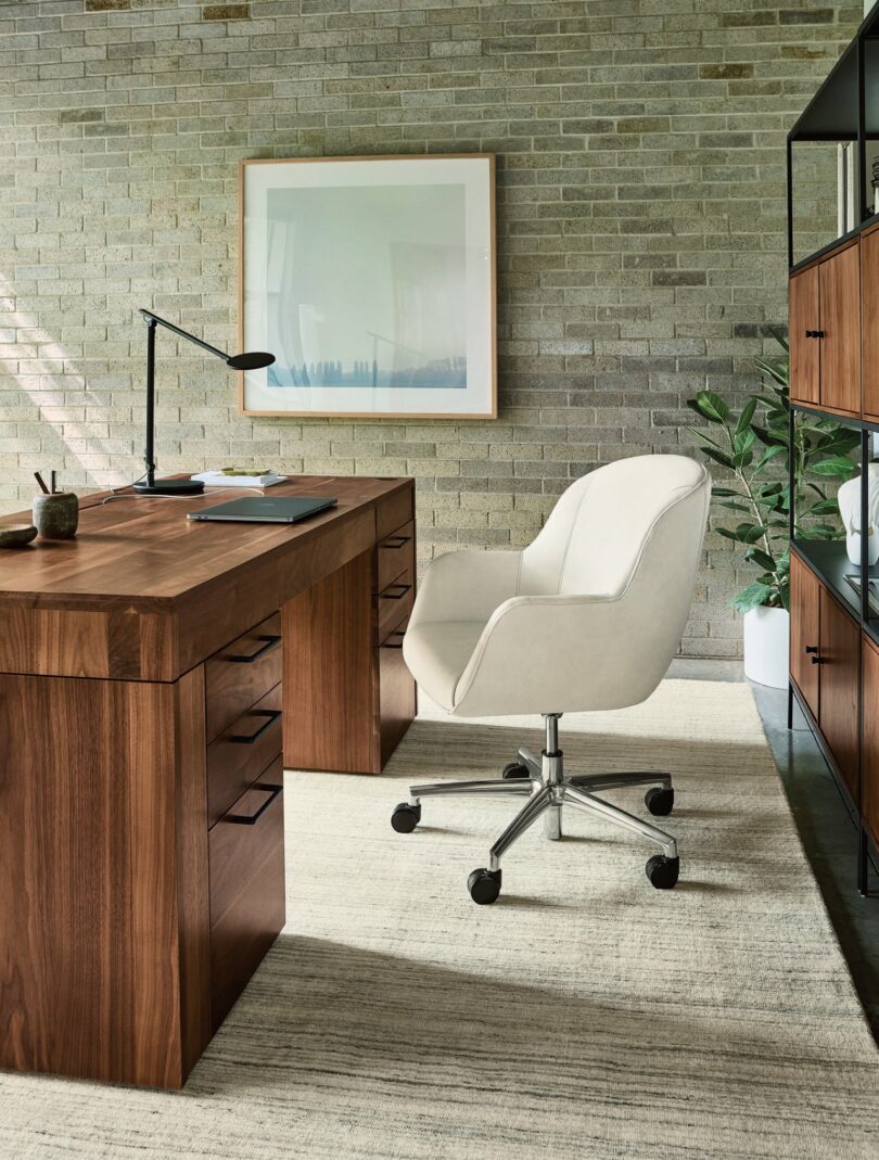 A close-up of the Lincoln desk showing its natural wood grain and rounded edge profile in a bright office setting.