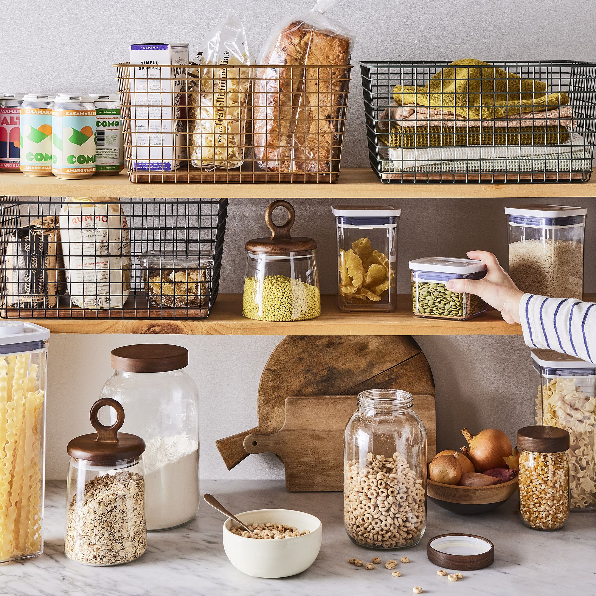 An assortment of 15 different kitchen organization products including turntables, clear containers, and wire baskets.