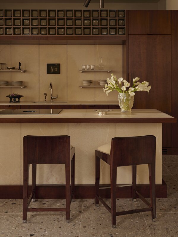 Modern kitchen in The Atelier featuring Honey Onyx vertical panels and dark walnut cabinetry.
