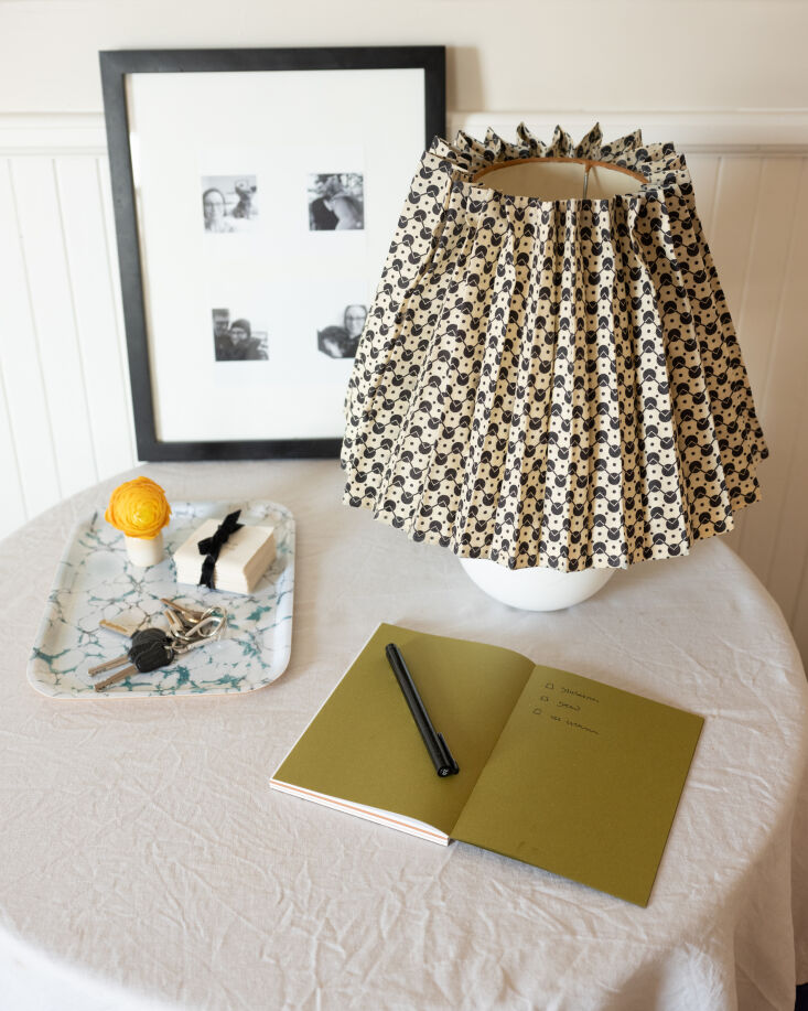 A small lamp with a floral patterned pleated shade in an entryway.
