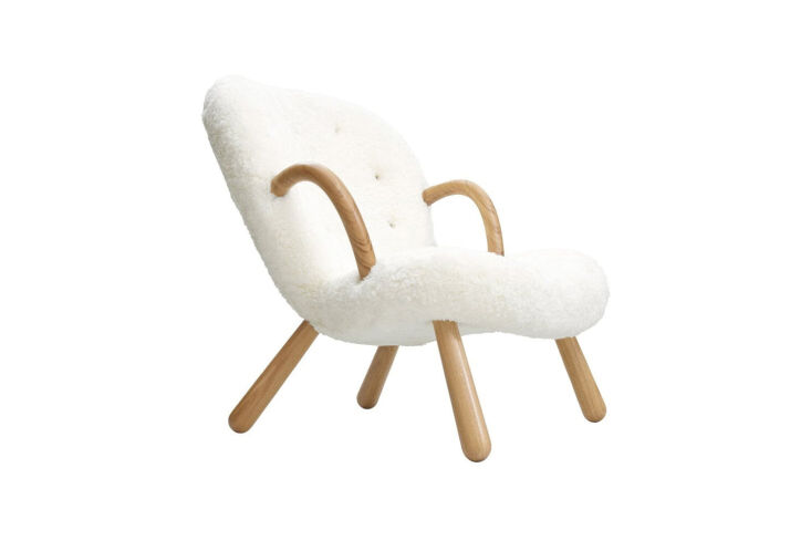 Philip Arctander Clam Chair with its characteristic shell-like sheepskin seat and rounded wooden arms.