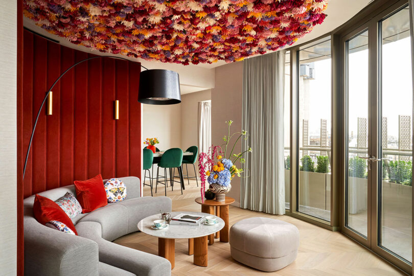 Living area at BoTree Hotel with a floral patterned ceiling and a red accent wall.