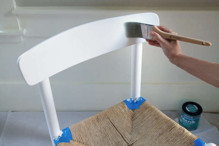 A chair receiving a second coat of sleek grey paint.