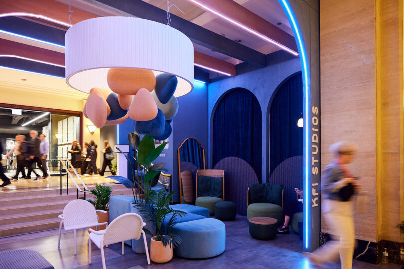 Modern colorful lobby with abstract lighting, blue walls, and KFI Studios signage.