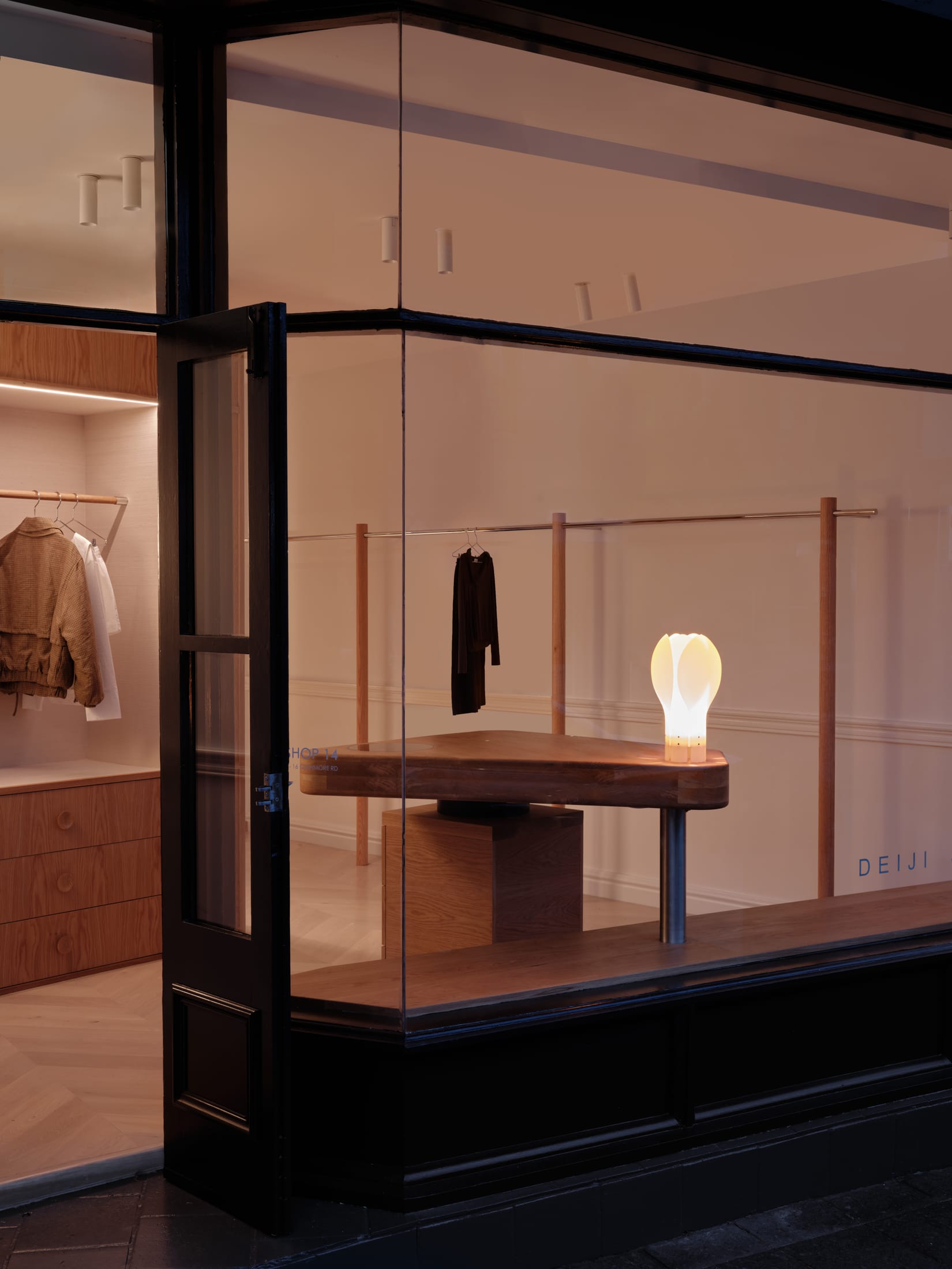 A perspective view of the store showing the balance between the polished stainless steel and warm wood.