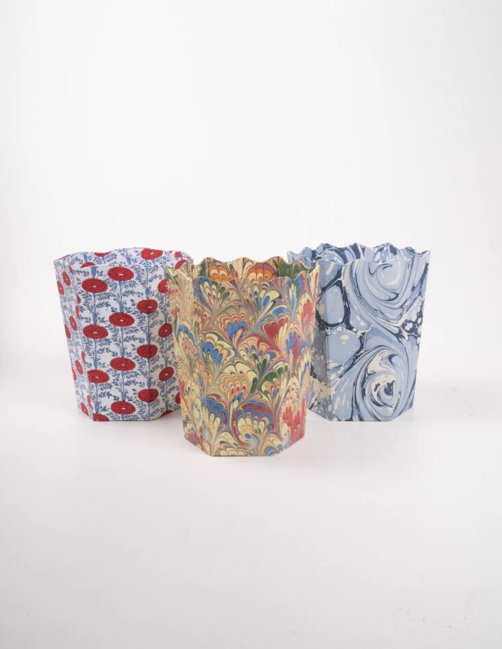 A hand-marbled, scalloped-edge paper waste bin with a blue and white ocean wave pattern.