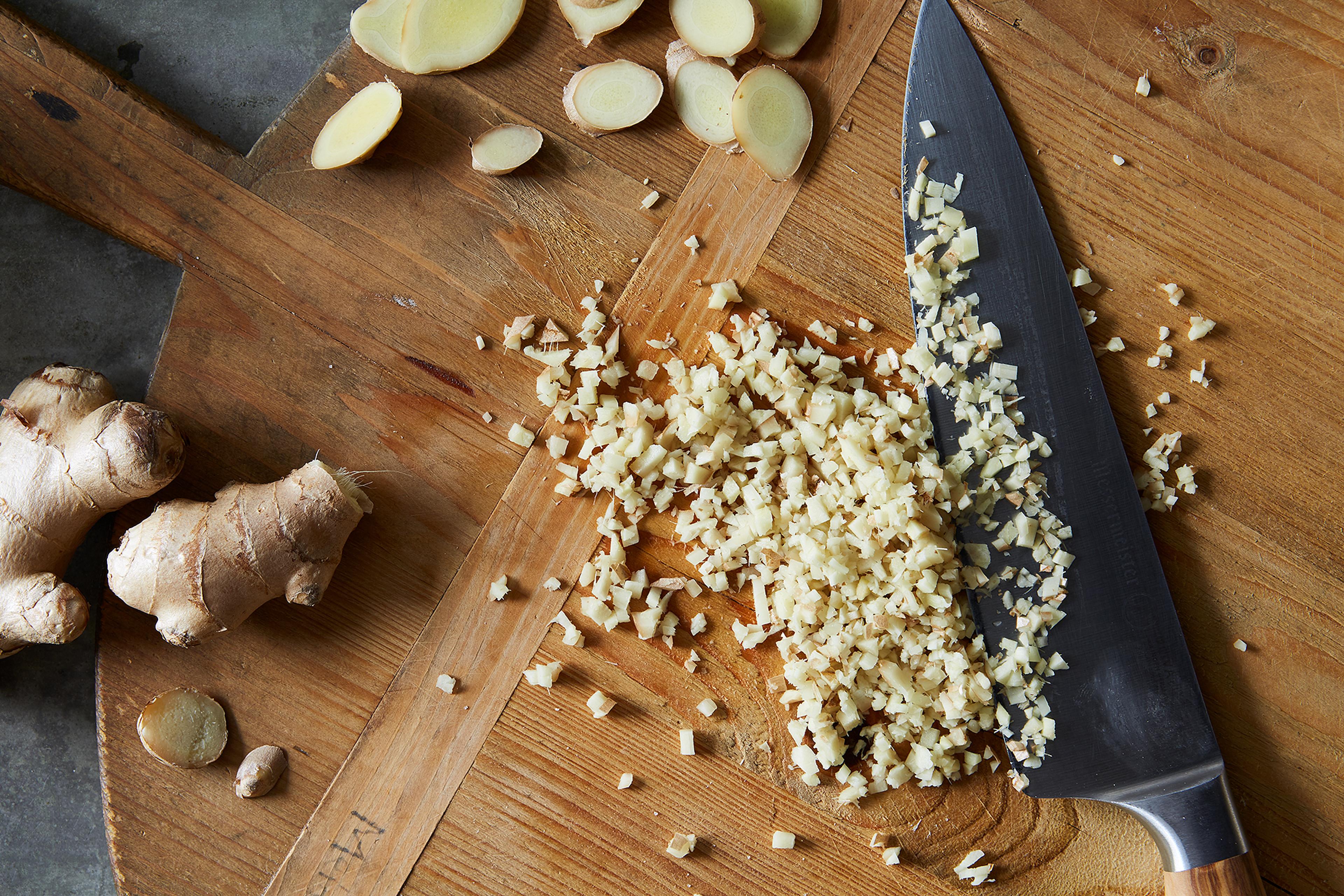 Freshly julienned ginger strips on a wooden cutting board.