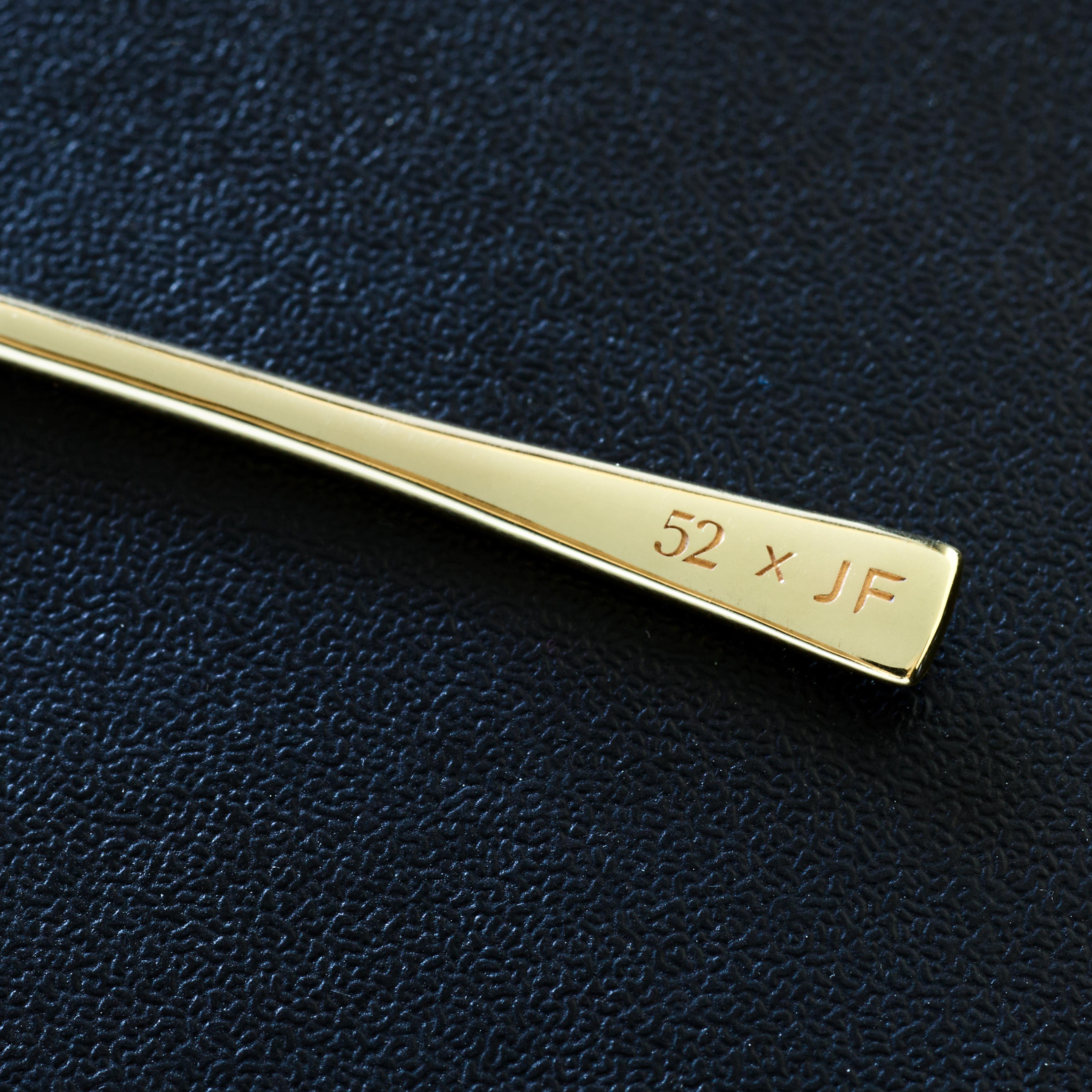 Macro close-up shot of the engraved tip of a 14k gold toothpick.