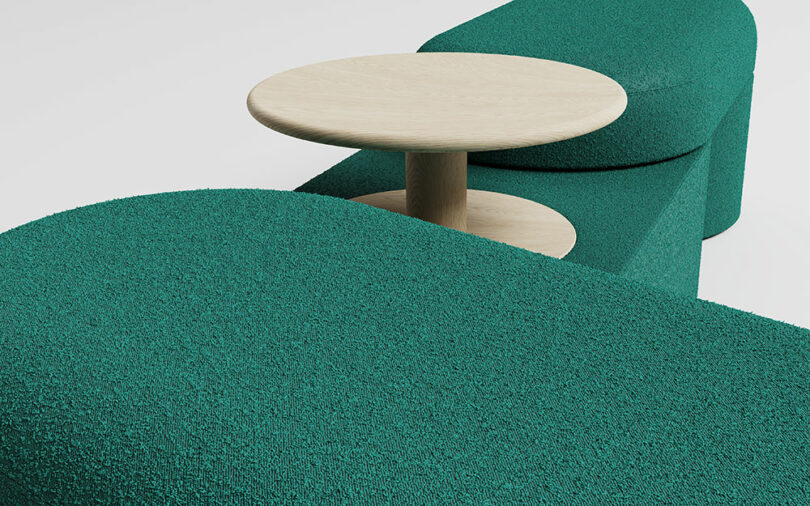 Teal curved seating with a low backrest and integrated side table.