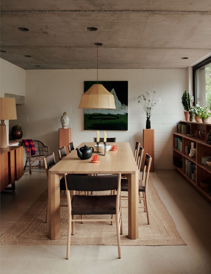 Sunken dining room with an oak Mead dining table, Avery chairs, and a Soren 600 pendant light.