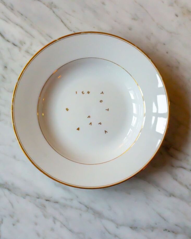 A white porcelain bowl with the hand-lettered gold inscription 'À bientôt, papa'.