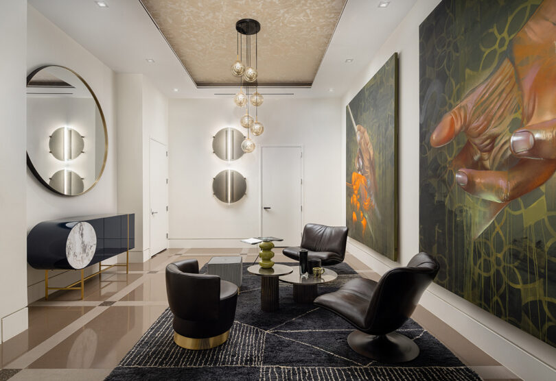 A modern lounge with black leather chairs and artistic wall decor in a high-end audio showroom.