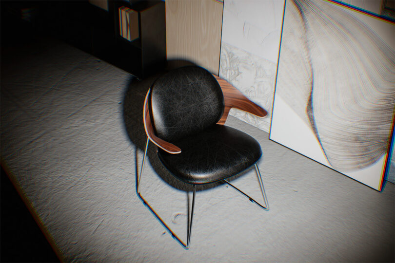 A modern black version of the Mysa chair with wooden armrests in a room with a bookshelf.