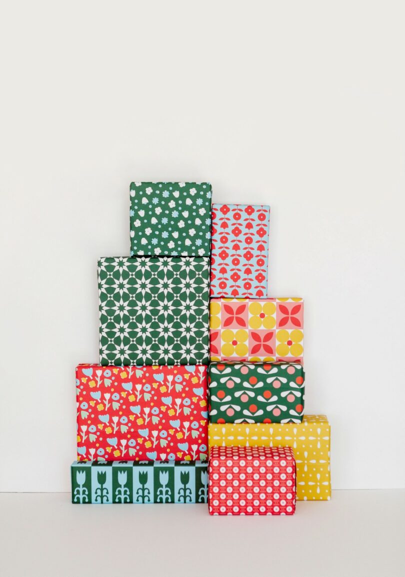 Pyramid of gift boxes wrapped in various colorful geometric and floral patterns.