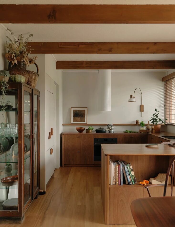 Interior view showcasing exposed timber ceiling beams and custom wood joinery in a kitchen.
