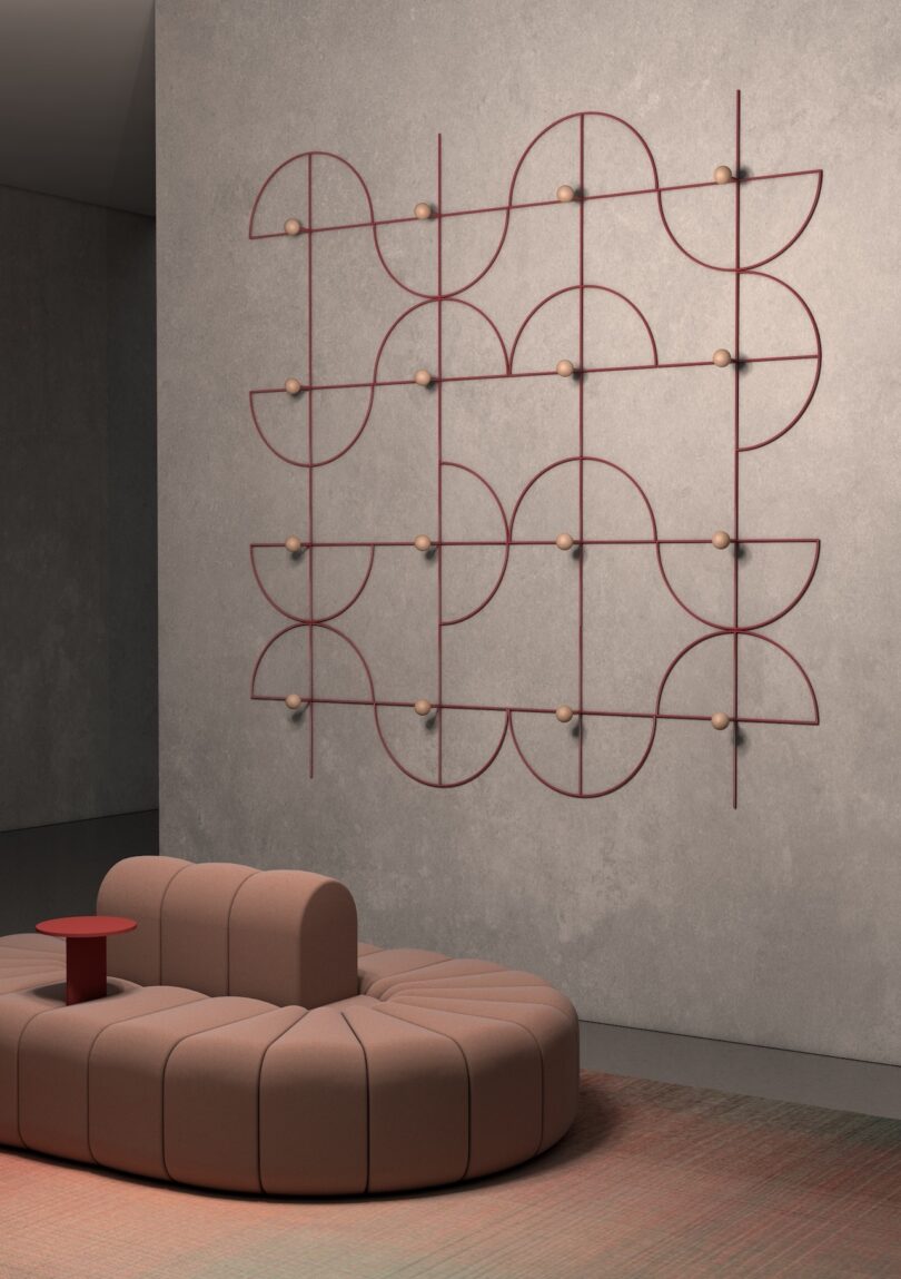 Modular brown sofa below a wall sculpture with intersecting red lines and circular nodes.