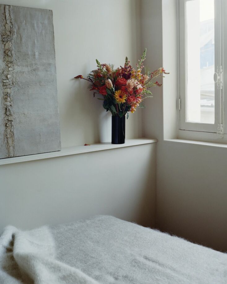 A glass partition wall with a display ledge separating living zones in a studio.