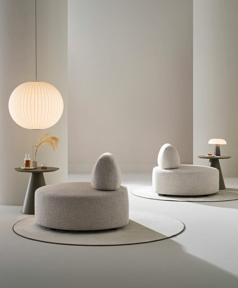 Two cylindrical lounge chairs with curved backrests positioned for conversation in a modern interior.