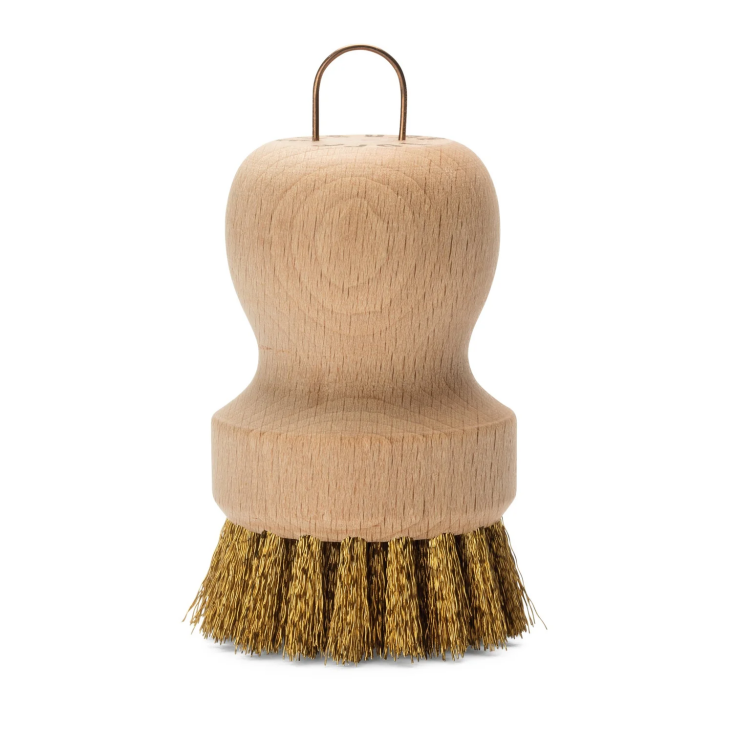 A wooden pot brush with brass wire loop detailing.