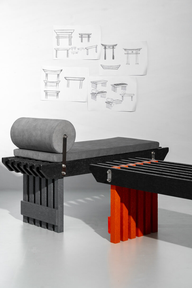 A modern bench in front of wall-mounted design sketches and diagrams.