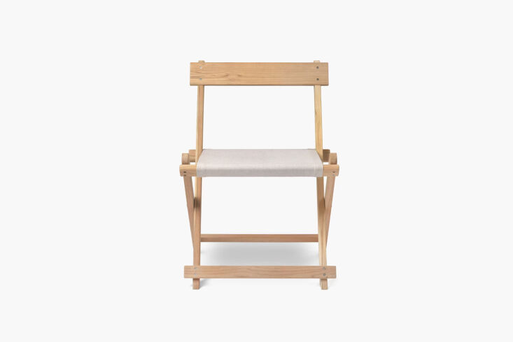 Scandinavian style teak folding dining chair with a slatted backrest and seat.