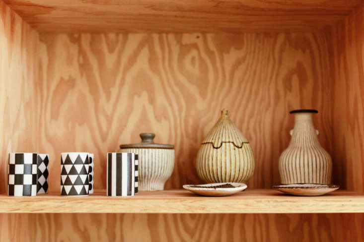 Close-up of simple plywood shelving and minimalist ceramic sake cups.