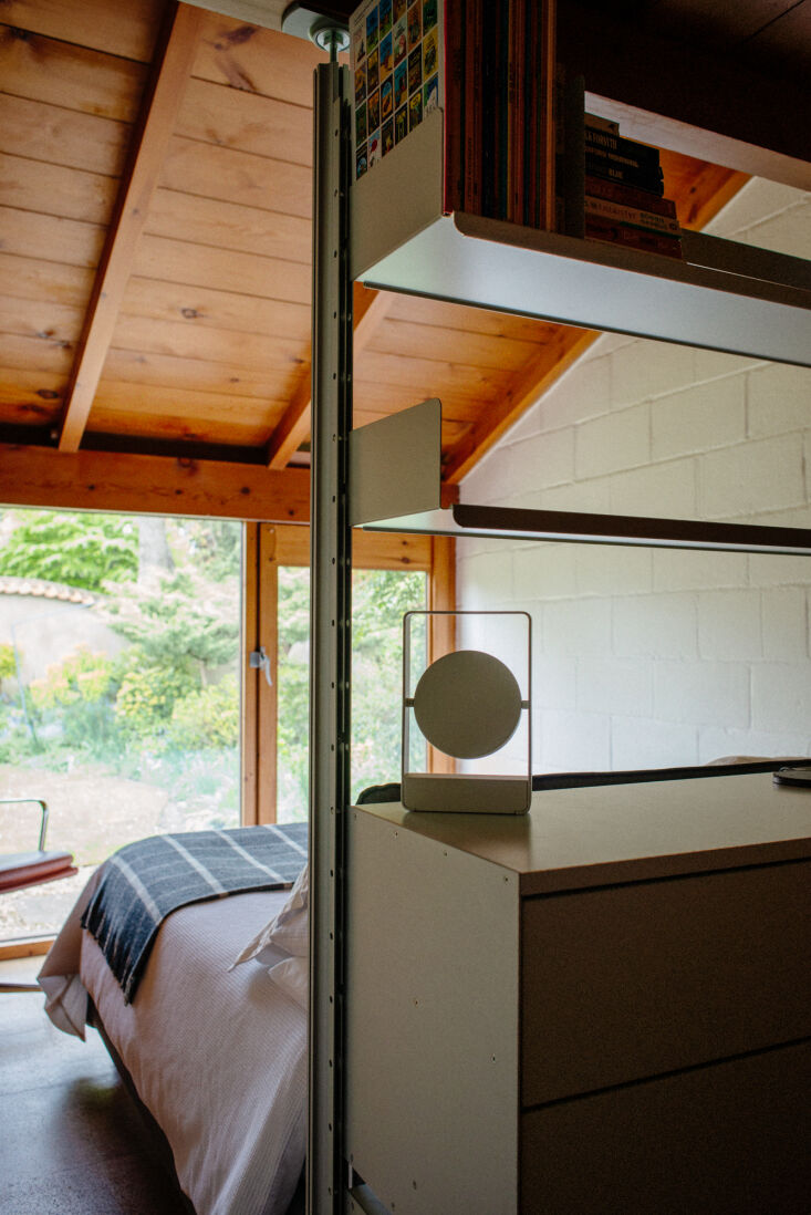 View from an interior room looking out through a large glass pane into a lush, private garden.