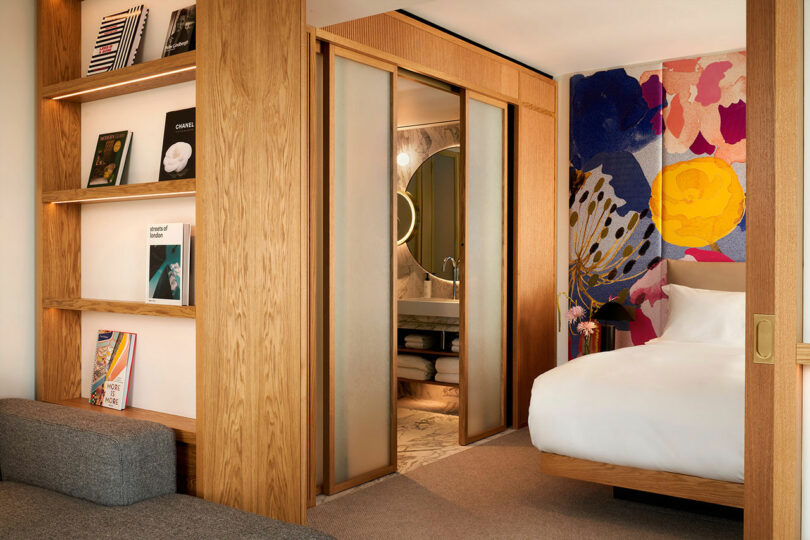 Wooden sliding door separating the bedroom from the bathroom in a hotel room.