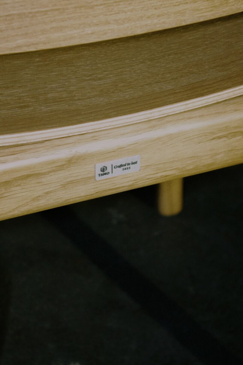 Close-up of a wooden chair part with a hand-crafted label reading 'TAKO Crafted by hand 1992'.