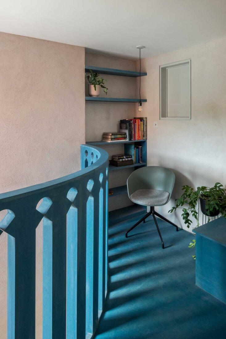 A bright blue CNC-cut Valchromat balustrade on a mezzanine overlooking the kitchen area.