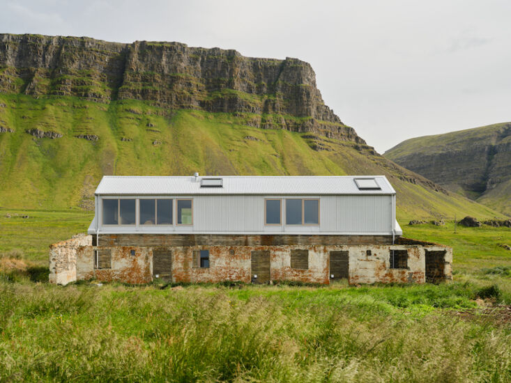 A roofless concrete ruin converted into a small garden with plants and flowers protected by thick walls.