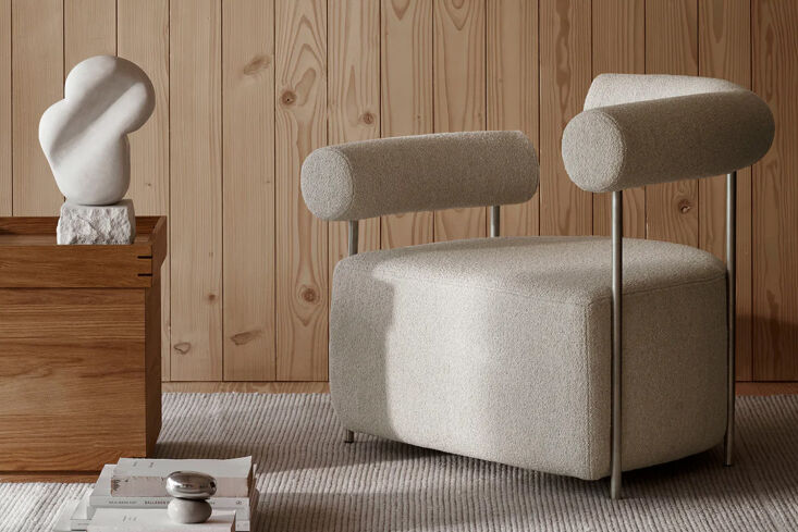 The Solitude Lounge Chair with a minimalist angular chrome frame and white bouclé upholstery.
