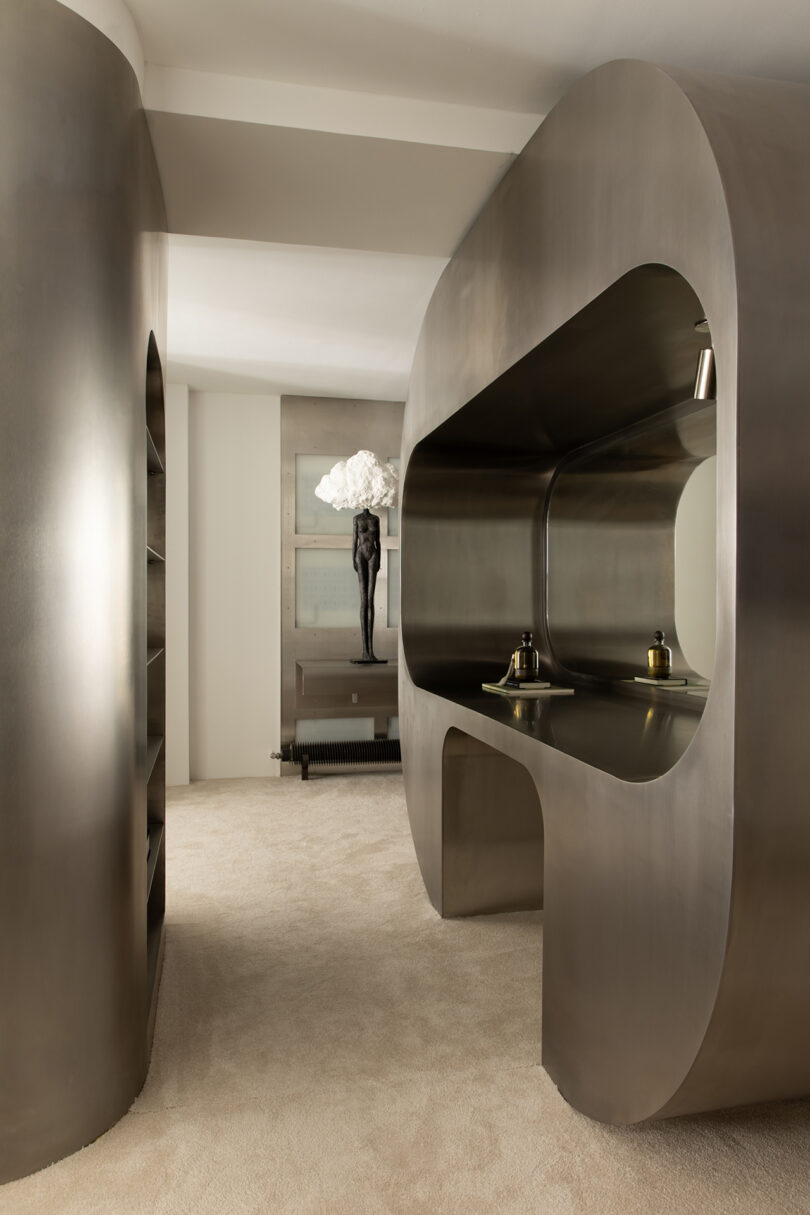 Modern interior featuring curved metallic structures and a minimalist work desk.