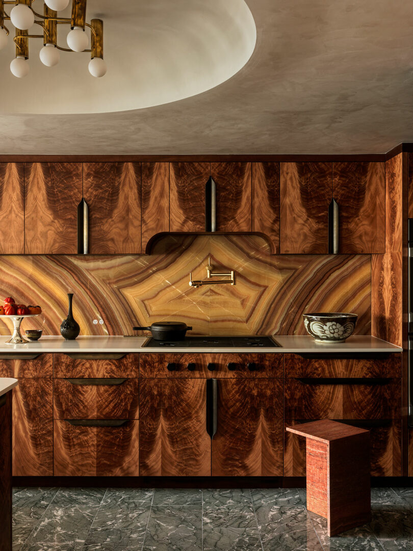 Modern kitchen in the Watergate project featuring bookmatched wood cabinets and a green marble floor.