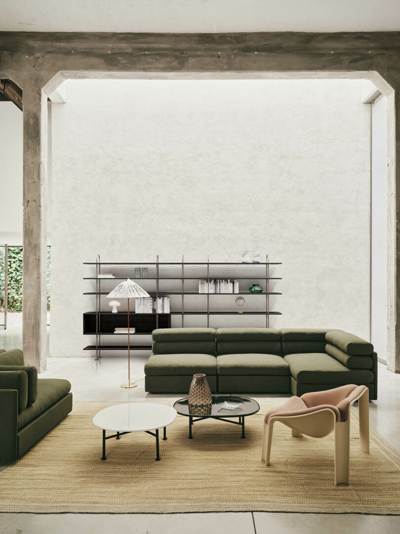 The Elogio sofa in a large living room with high concrete beams and minimalist decor.