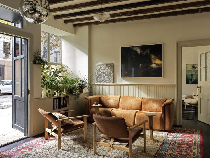 A cozy office waiting room featuring a leather sofa and a disco ball hanging from the ceiling.