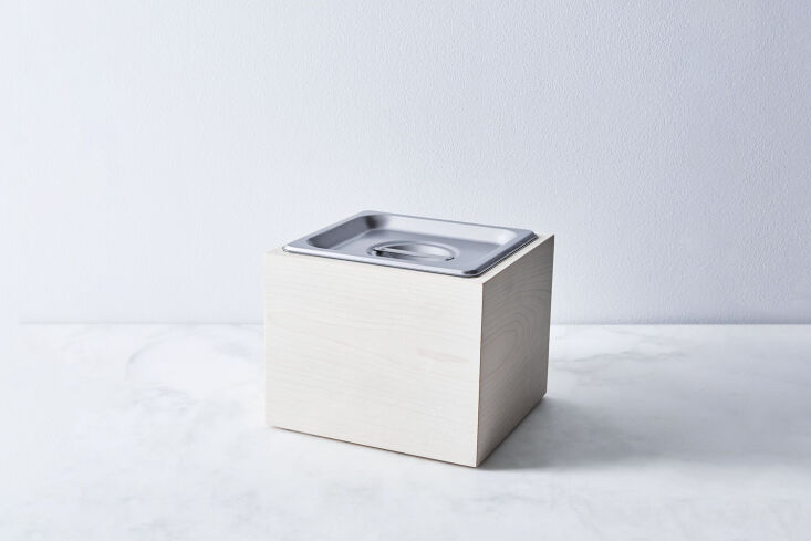 A luxury walnut wood compost bin with a sleek magnetic lid on a white countertop.