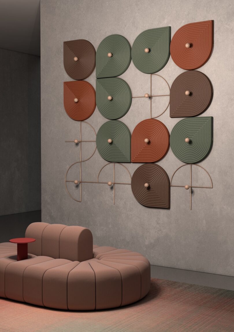 Modular beige sofa on a multicolored carpet with green and brown geometric wall art.