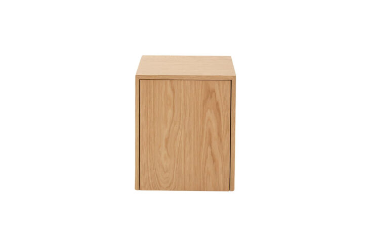 A minimalist oak veneer side table with a single drawer partially open on the side.