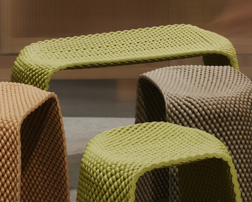 A group of woven-texture stools in muted earth tones like yellow, beige, and brown.