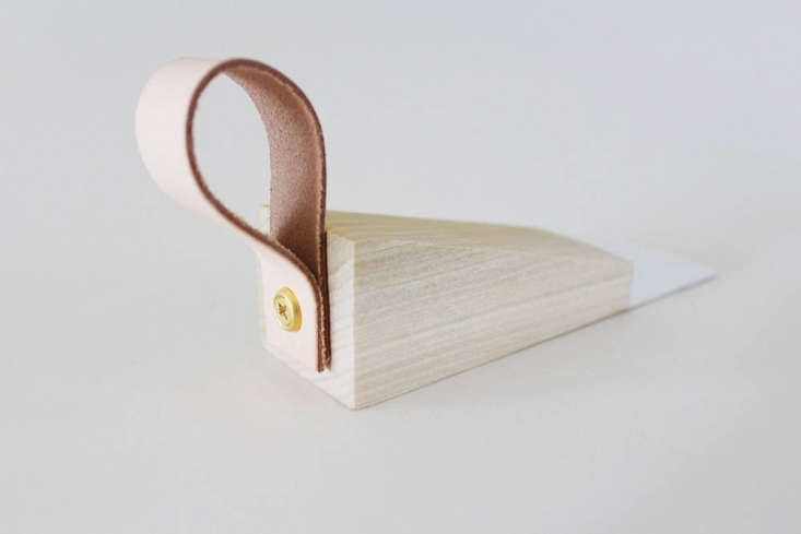 A drill attaching a leather loop to the back of the wood wedge using a brass washer.