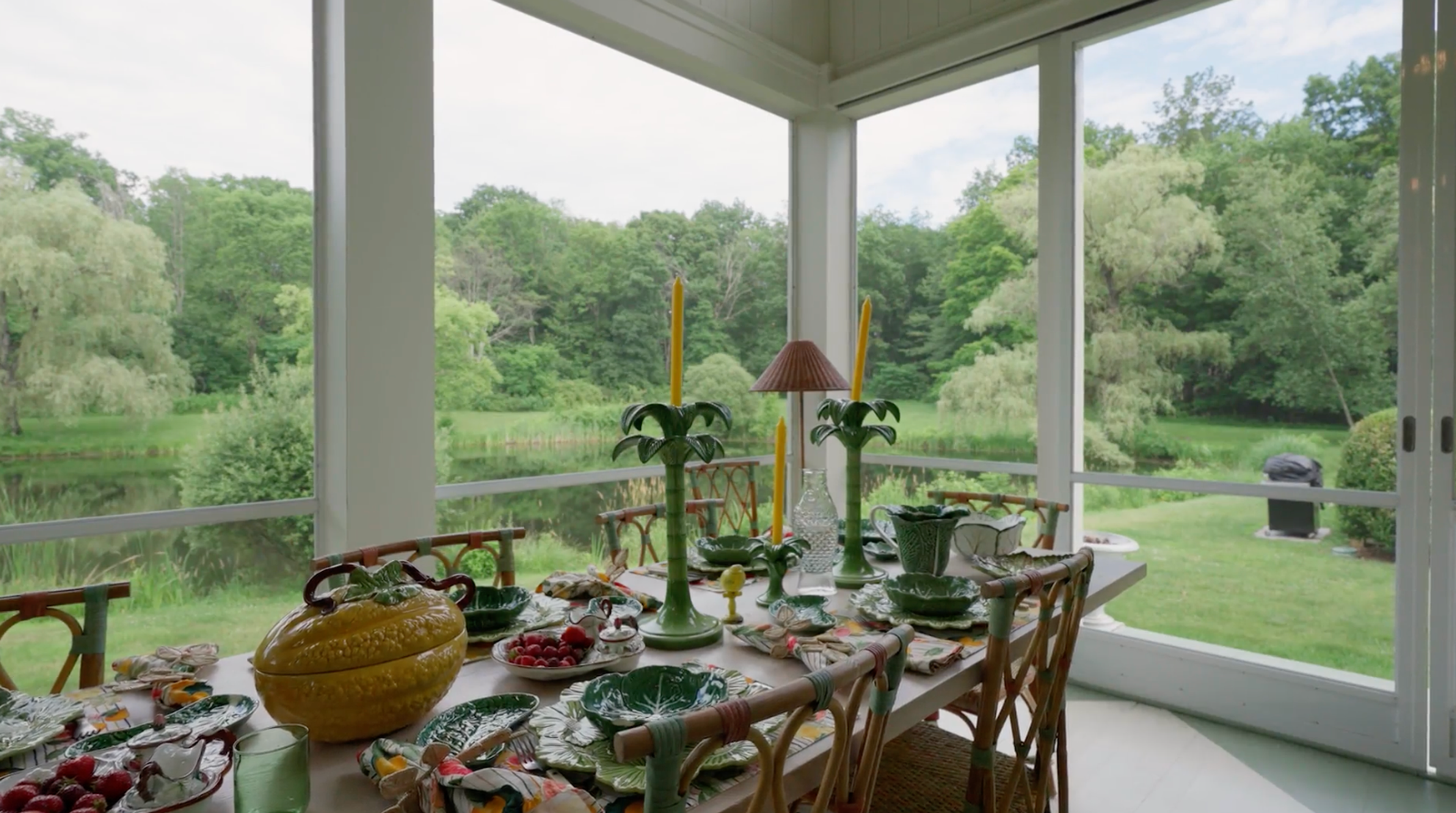 A large wooden dining table set on a spacious, covered porch.