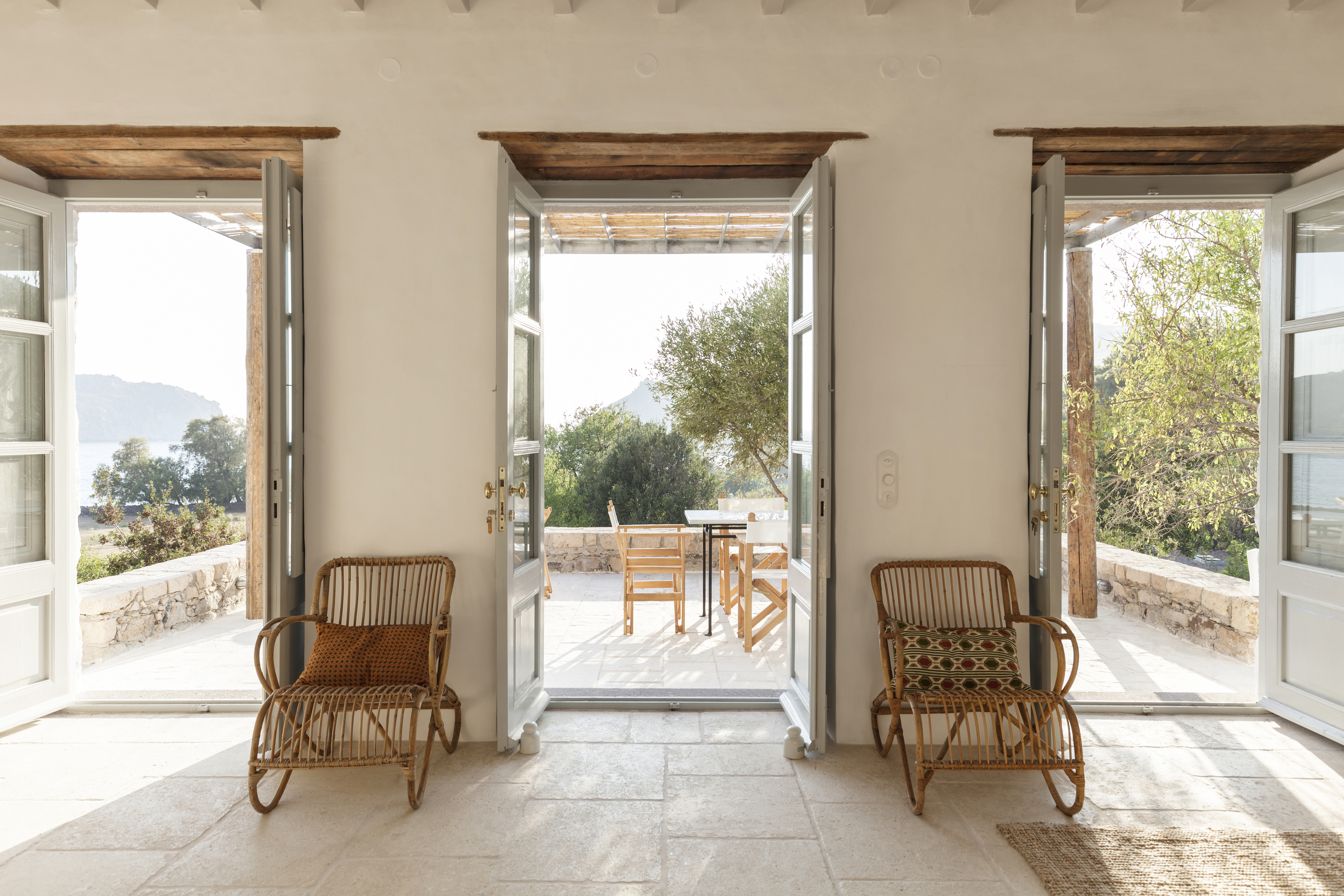 Wide shot of a Greek island living room with built-in seating and traditional architecture.