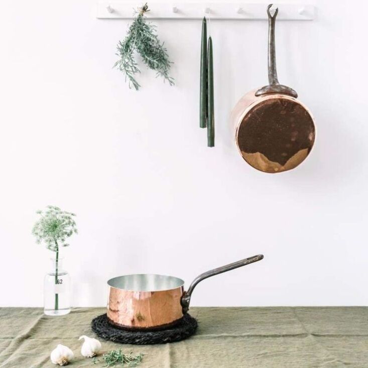 A collection of shiny, re-tinned vintage copper saucepans and pots.