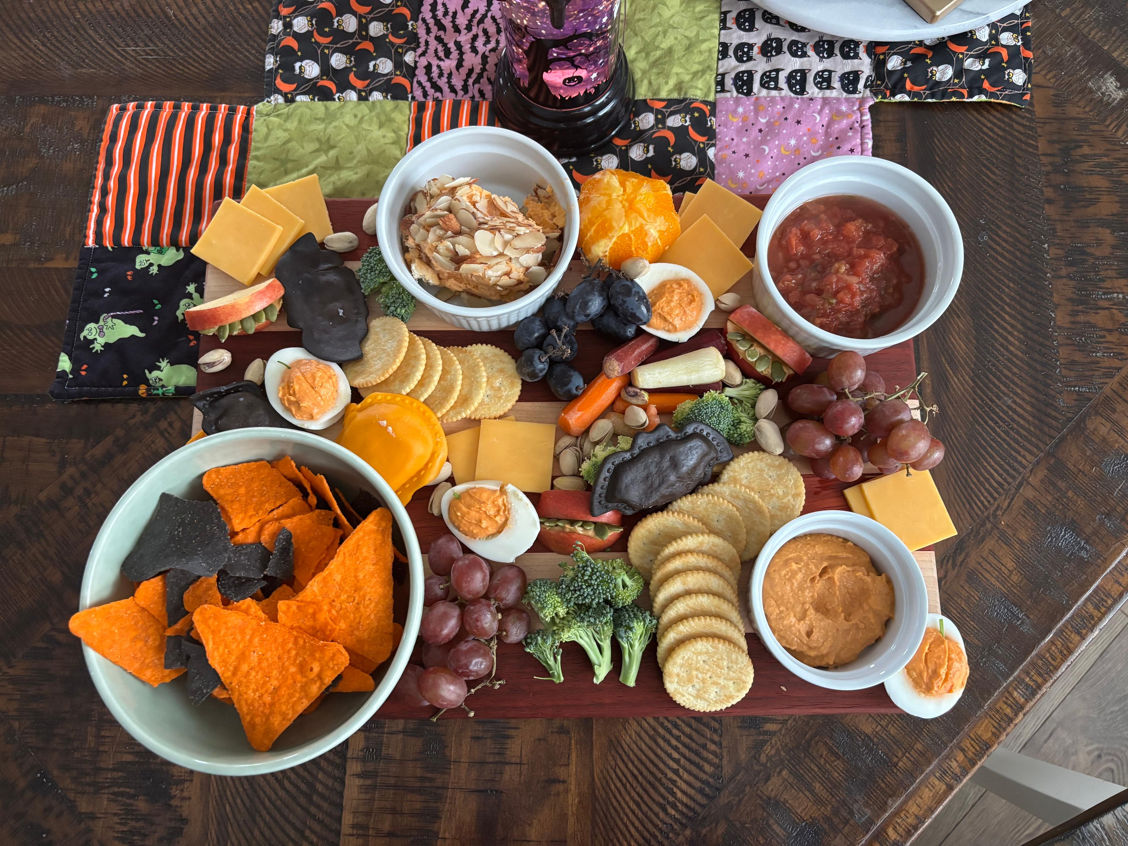 A snack plate creatively arranged with a Halloween theme using oranges and pretzels.